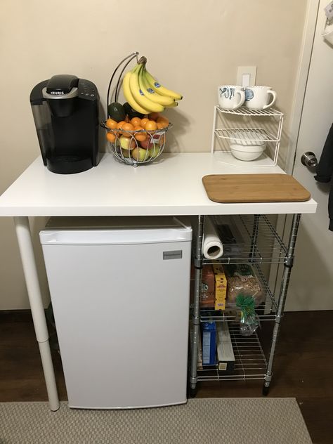 Mini fridge storage idea  IKEA desk top— $8.99 IKEA adjustable legs (2)— $30.00 IKEA food storage shelf— $18.99 KEYSTONE white mini fridge— $149.99 Shelf For Mini Fridge, Dorm Dishes Storage, Room Food Storage Ideas, Studio Apartment Mini Fridge, Mini Fridge And Microwave Stand, Dorm Fridge Stand, Dorm Room Ideas Mini Fridge, Mini Desk Fridge, Over The Fridge Storage Dorm