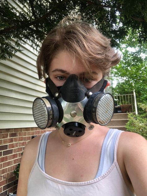 a selfie of me, a white teenager with short brown hair that falls in my face, wearing a respirator from the ‘40s. i’m wearing a black cloth mask under it, and a cream tank top. i look neutral. i’m standing in from of a brick building and there’s a tree branch above me. Mask Reference, Scuba Diving Pictures, Mask Aesthetic, Zombie Art, Female Pilot, Reference Art, Half Mask, Mask Girl, Gas Mask