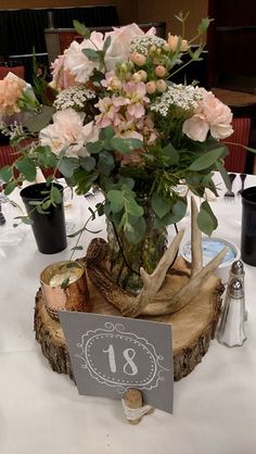 Rustic reception centerpiece peach flowers in hobnob jar on wood slice surrounded by deer antlers. Wood Slice Centerpiece, Cheap Wedding Table Centerpieces, Rustic Reception, Beautiful Wedding Centerpiece, Wedding Reception Planning, Antler Wedding, Reception Centerpieces, Wedding Centerpieces Diy, Peach Flowers