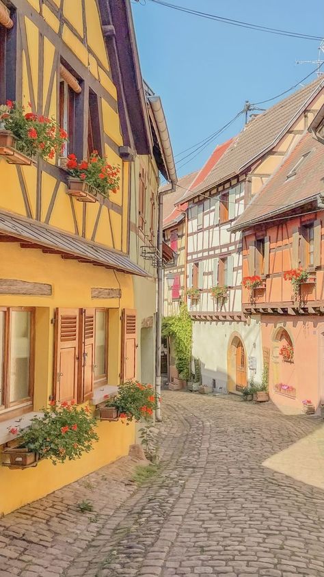 pastel streets of one of the most beautiful town in France to visit Eguisheim Europe Town Aesthetic, Town Reference Photo, Small French Town Aesthetic, Small Town France, Cottagecore Town Aesthetic, City Landscape Reference, Pastel Country Aesthetic, Small French Town, Cute Town Aesthetic