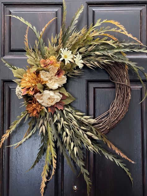 Bring the feeling of fall into your home with this wreath composed of mountain fern, oat seeds, peonies, hydrangeas, dahlias, and petite berries. This wreath features a mix of beige, brown, and green colors for a more realistic fall look. Add this piece to your front door or your wall for a look inspired by autumn this season.  [ Measurements ] Height: 25 in Width: 20 in Depth: 6 in Fall Decor Floral, Fall Wreath With Velvet Ribbon, Trending Wreaths 2024, Harvest Wreaths For Front Door, Fall Boho Wreath, Minimalist Fall Wreath, Modern Fall Wreaths For Front Door, Autumnal Wreaths, Fall Wreath Ideas Diy