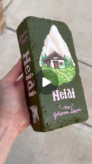 Melani Alberts on Instagram: "What book should i do next?? The”Mountain Song” by @tophousetheband completely inspired me to do this next book. It is Heidi by Johanna Spyri. 

Supplies brick @homedepot paint @michaelsstores paint markers @grabieofficial @shuttleartllc @amazon sealant @krylonbrand 

#gardendiy #brickpaverbook #brickpaverbooks #brickbooks" Brick Painting Ideas Craft, Book Bricks, Painted Bricks Crafts, Brick Painting, Painted Bricks, Brick Crafts, Johanna Spyri, Brick Pavers, Painted Brick