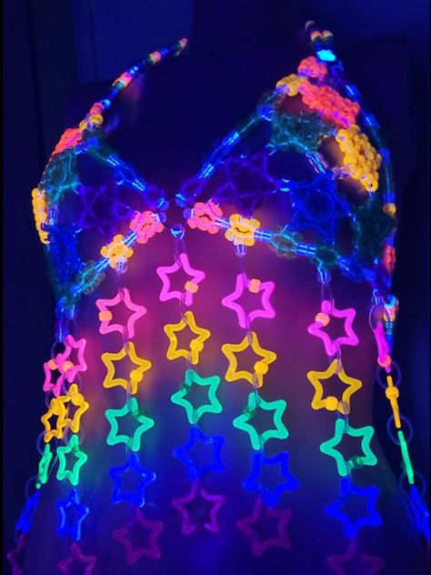 Unleash your inner star with the Glitter Star Kandi Harness! This dazzling festival outfit is a showstopper, featuring a mesmerizing kandi bra adorned with sparkling glitter stars. It’s the perfect rave clothing to elevate your style and make you shine on the dance floor. Get ready to slay in this gogo-inspired festival top! Glitter Star Kandi Harness on GlowInTheDarkStore.com Rave Outfits Glow In The Dark, Kandi Bra, Kandi Harness, Festival Kandi, Fishnet Bodysuit, Kandi Ideas, Glow Stars, Star Clothing, Rave Clothing