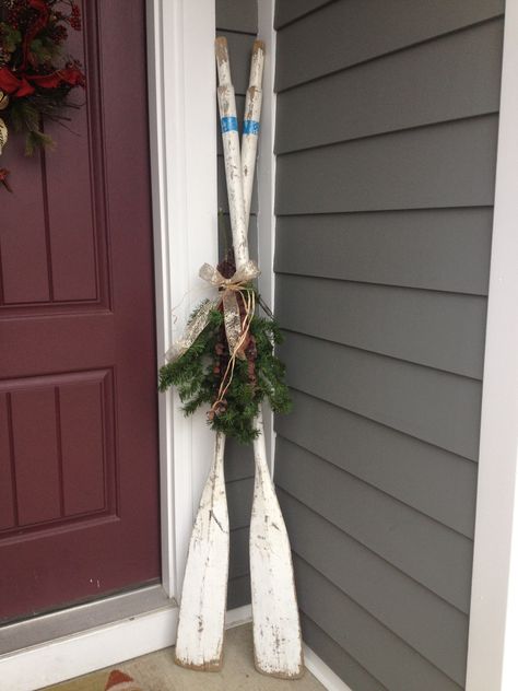 Vintage oars Christmas porch decor at the lake Oars Decor Ideas, Christmas Lake House Decor, Old Oars Decor, Lake House Christmas Tree Ideas, Christmas Lake House, Lakehouse Christmas Decor, Lake Christmas Decor, Christmas At The Lake, Paddle Decor Ideas