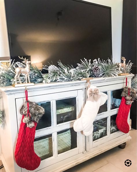 No mantle no problem!! 😍 your TV stand can work as your stocking holder for the holidays! 🙌🏼❤️ just cute some cute stocking holders (these sparkles reindeer are only $10!) and some garland (only $20!) ❄️📲 You can instantly shop all of my looks by following me on the @liketoknow.it app! http://liketk.it/2yxB3 #liketkit #LTKholidaystyle #LTKholidayathome #LTKeurope #LTKsalealert #LTKstyletip #LTKunder50 Tv Stand Stocking, Stocking On Tv Stand, Christmas Stockings On Tv Stand, Tv Stand Christmas Garland, Tv Stand Garland Christmas, Garland On Tv Stand Christmas, Christmas Stocking No Mantle, Christmas Garland On Tv Stand, Stockings On Tv Stand