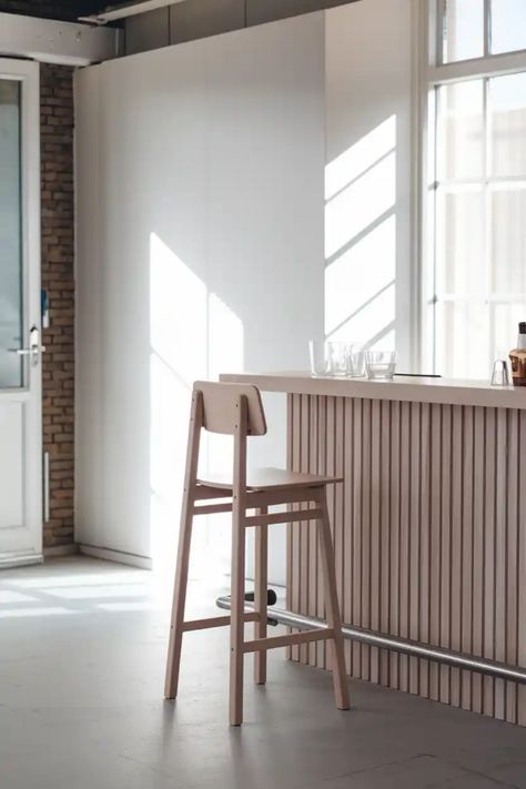 Minimalist kitchen with a wooden bar stool by a slatted counter, bathed in natural light from tall windows. Unique Bar Stools, Unique Seating, Tall Stools, Tall Bar Stools, Contemporary Bar Stools, Bar Stools With Backs, Modern Stools, Stools With Backs, Swivel Stool