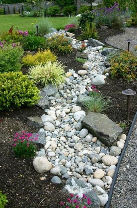 a beautiful and low maintenance garden incorporating a river rock dry stream with herbs and blooms around Stream Landscaping, Dry Stream, River Rock Garden, River Rock Landscaping, Small Front Yard Landscaping, Rock Garden Design, Front Yard Design, Creek Bed, Rock Garden Landscaping