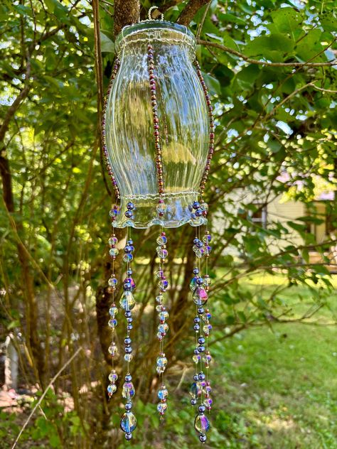 Beautifully handcrafted and one-of-a-kind, this hanging orb will add a touch of magic to your home, porch, or yard!  Each "jellyfish" is made with a reclaimed piece of decorative glassware, artfully wrapped in silver-plated copper wire, and adorned with a unique selection of high-quality beads, strung on heavy-duty fishing line.  Glass Diameter: 4.5" Glass Height: 8" Bead Length: 8" Total Length: 16" Item Weight: 14.6 oz *Glassware is thrifted and may show signs of wear, such as minor chips or scratches. Please contact seller if you suspect damage has been caused during shipping. Witchy Boho Home, Esoteric Aesthetic, Window Porch, Occult Decor, Witchy Boho, Home Decor Colorful, Purple Rainbow, Funky Style, Hanging Beads