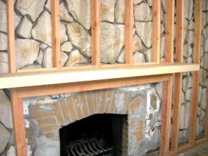 Want to get rid of an old rock wall but it requires too much demo? Cover it up with framing and drywall. Mantel On Rock Fireplace, Covering Up Stone Fireplace, How To Update Rock Fireplace, Rock Wall Fireplace Makeover, Stone Wall Fireplace Makeover, Old Rock Fireplace Makeover, Update Stone Fireplace, River Rock Fireplace Makeover, Rock Fireplace Ideas