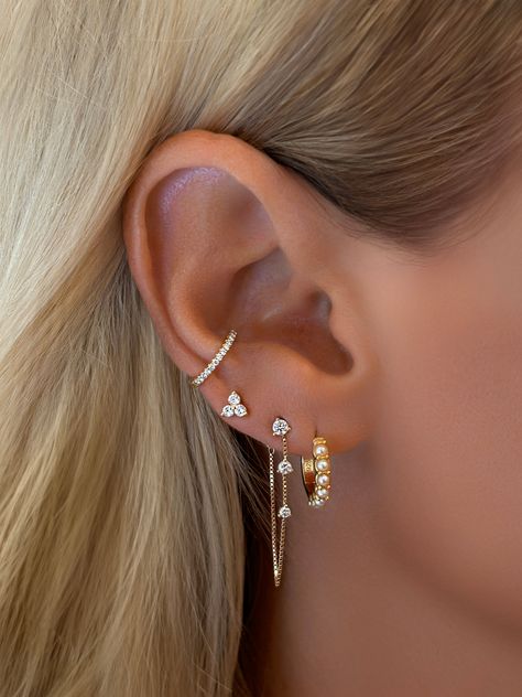 Enhance your look with our Trio Flower Cluster Stud Earrings. These pretty studs feature a trio of delicate flowers, each with a subtle sparkle, perfect to wear in your ear lobe and cartilage. Styled on our model, Hailey with Vermeil Spike Dagger Drop Huggie EarringsStyled on our founder, Emily withVermeil Pearl HuggiesFine White Topaz Dangle Chain Stud Earrings Size: 4mm ClusterStone: Cubic ZirconiaMaterials: Sterling Silver & 14K Gold Vermeil Earrings For 4 Holes, Multiple Ear Piercings Small Ears, Four Earrings Piercings, Lobe Earrings Triple, 3 Pericing Ideas, Earring Stack 3, Ear Lobe Piercings Triple, Blue Earring Stack, Cute Earring Stacks