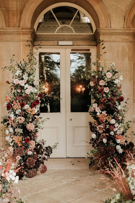 Pale pink and red autumnal wedding flower column decorations Light Burgundy Wedding, Flower Arches For Weddings, Fall Pinks Wedding, Fall Flower Arch Wedding, Rusty Red Wedding, City Wedding Flowers, Classy October Wedding, Ballroom Wedding Flowers, Blush Autumn Wedding