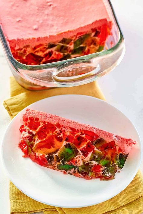 Step back in time with the enchanting Crown Jewel Dessert, a delightful symphony of colors and flavors! Also known as Broken Glass Jello or Stained Glass Jello, this retro treat is a mosaic of lime, orange, and strawberry gelatin cubes, suspended in a creamy Jello mix. Each bite of this vintage masterpiece offers a burst of fruity flavor, beautifully contrasted with the creamy sweetness of whipped topping. Get the easy recipe and find out how to make this whimsical dessert. Mosaic Jello Recipe, Vintage Jello Molds Recipes, Stained Glass Jello, Jello Mold Recipes Vintage, Creamy Jello, Broken Glass Jello, Glass Jello, Vintage Lime Jello Salad, Orange And Strawberry