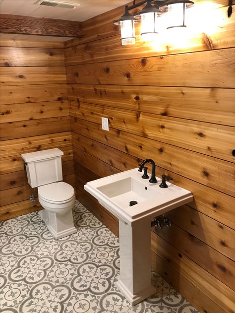 My beautiful bathroom! Best Husband Ever 💜 Cedar Shiplapped Walls, Cement Tile Floor (TileShop.com) with off white grout, 2X6 pine painted white shiplapped ceiling, light fixture above sink is from Menards for $100, toilet, sink and faucet are all Koehler. Pine Walls Bathroom, Cabin Bathroom Floor, Cedar Shiplap Wall, Adaptive Bathroom, Cedar Bathroom Walls, Cedar Walls Interior, Cedar Bathroom, Pine Shiplap Wall, Bathroom Floor Ideas