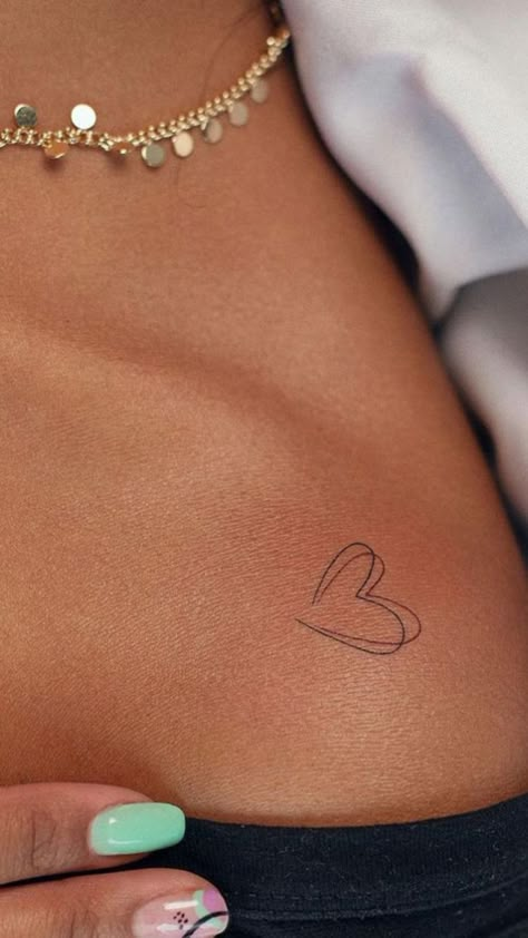 11 Heart Tattoos That'll Bring Out Your Inner Romantic Geometric Feminine Tattoo, 40th Tattoo Ideas, Open Heart Tattoo On Collar Bone, Love Heart Tattoos For Women, February Birthday Tattoo Ideas, Collarbone Heart Tattoos For Women, Small Heart Collar Bone Tattoo, Heart Cheek Tattoo, Small Heart Tattoo Placement Ideas