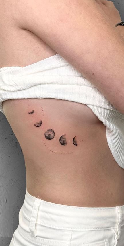 << Check out more Moon Phase Tattoos, Ideas and Meanings #tattoomenow #tattooideas #tattoodesigns #tattoos #Moonphase #Moonphasetattoo Moon Phase Back Tattoo Women, Moon Phase Tattoo Ribs, Planets Down Spine Tattoo, Moon Changes Tattoo, Ribcage Moon Tattoo, Stages Of The Moon Tattoo, Women Ribcage Tattoo, Moonphase Tattoo Design, Spine Tattoos For Women Moon Phases