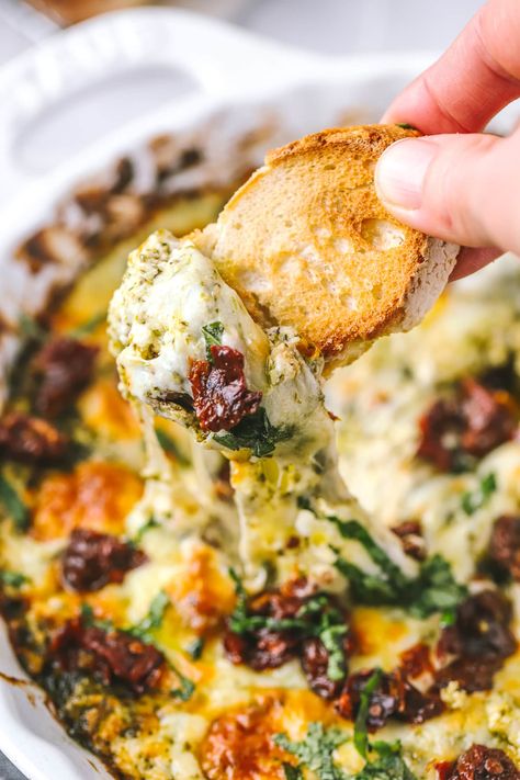 This easy cheesy baked pesto dip is packed with flavour and juicy sun-dried tomatoes. It's an easy appetizer for the holidays and game-day! Pesto Sundried Tomato Cream Cheese Dip, Easy Dinner Dips, Sun Dried Tomato Pinwheels, Sundried Tomato Appetizer, Goat Cheese Sun Dried Tomato Appetizer, Tuscan Cheese Dip, Southern Dips, Last Min Appetizers, Pesto Appetizers Appetizer Ideas