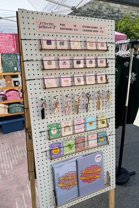 Use a pegboard to display your pins, keychains, and other small items at your market stall. This is a great way to show off your products and make them easy for customers to find. #marketstall #displayideas . #Pin_Display_Ideas_Market #Dollar_Tree_Pegboard_Display #Market_Display_Ideas #Magnet_Display Market Display Ideas, Market Signage, Enamel Pin Design, Pegboard Ideas, Shirt Displays, Art Fair Booth, Patches Display, Vendor Booth Display, Pegboard Display