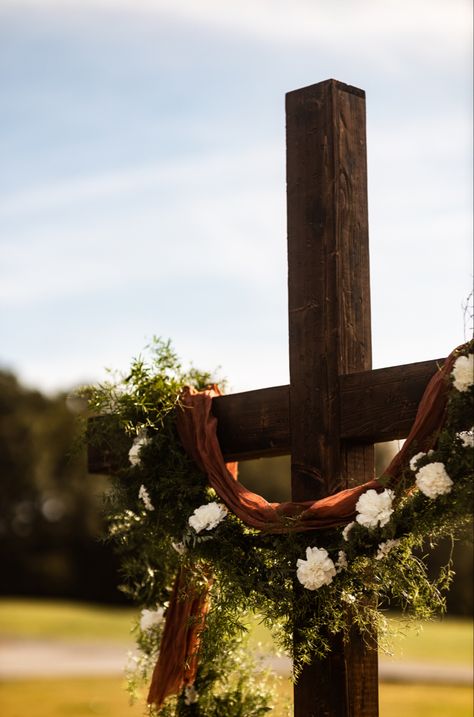 Beautiful cross with terracotta cheese cloth, greenery garland and white floral accents Cross Arbor Wedding Fall, Wedding Cross Altar Outdoor Ceremony, Cross Arbor Wedding, Cross Alters For Weddings, Cross Altar Wedding, Cross Wedding Alter, Wedding Cross Decor, Cross For Wedding Ceremony, Wedding Alter Decor