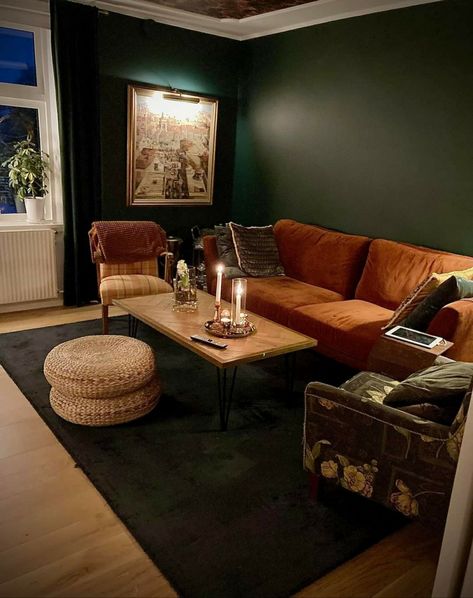 Dark Green Orange Living Room, Moody 70s Living Room, Dark Green And Rust Living Room, Dark Green And Terracotta Living Room, Dark Cosy Living Room Ideas, Dark Green And Burnt Orange Living Room, Dark Green Moody Living Room, Dark Earth Tone Living Room, Dark Green And Orange Living Room