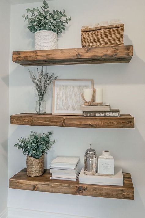 Use floating shelves to display aesthetically pleasing decor like candles, books, plants, and small framed art. To maintain a minimalist look, style the shelves with a limited number of items and ensure each piece complements the others in color and style. Great for living rooms, bedrooms, or kitchens.🛋✨ #FloatingShelves #StyledShelves #MinimalistDecor Wall Shelf Living Room Decor, Decorations For Floating Shelves, Floating Shelves Placement Ideas, White Floating Shelves Living Room, Floating Shelves Arrangement, Shelf Decor Living Room Wall Shelves, Floating Shelf Decor Bedroom, Kitchen Floating Shelves Decor Ideas, Floating Shelf Decor Living Room