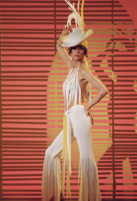 Cher sports a white halter-top, bell-bottoms, and feathered hat while promoting her CBS variety show “The Sonny & Cher Comedy Show” in 1972. Photo by CBS Photo Archive / Getty Images. 1960s Fringe, Cher Style, Cher 70s, Cher Fashion, Cher Looks, The Cher Show, Cher Show, Cher Outfits, Cher Photos