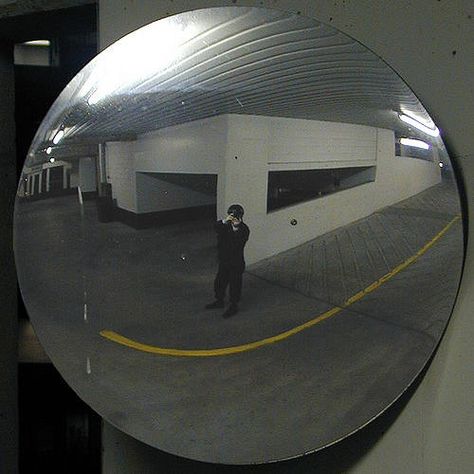 This is a convex mirror, and they are used in many enclose parking lots. The reason why convex mirrors are used in enclosed parking lots is that they provide larger viewing angles and provide a wider range of view. The reason for this is because the mirror creates a virtual demagnified image for the objects in the parking lot. Angle Of View Photography, Creepy Mirror Reflection, Parking Lot Mirror, Warped Mirror, Parking Mirror, Road Mirror, Street Mirror, Dark Cover, Mirror Hack