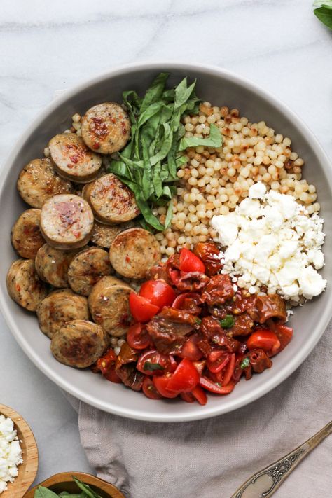 Garnished bowl of chicken sausage and bruschetta Sausage Bowl Healthy, Sundried Tomato Couscous, Chicken Sausage Salad Recipe, Chicken Sausage Couscous Recipes, Chicken Sausage Bowl Healthy, Sausage Bowl Recipes, Simple Bowl Recipes, Sausage And Couscous Recipes, Sundried Tomato Recipes Healthy