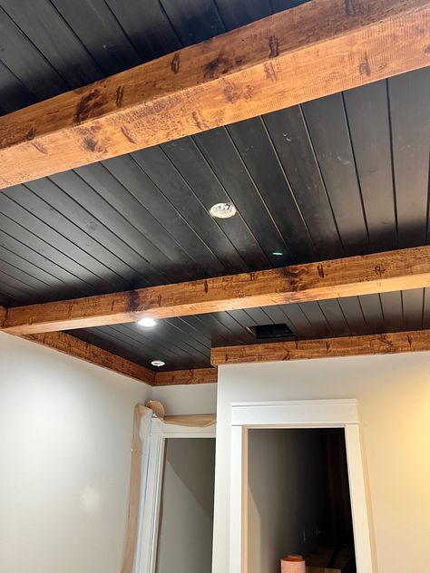 Wood Beam Basement Ceiling, Wood Beams On Bedroom Ceiling, Basement Wood Beams, Low Ceiling Cabin Ideas, Black Tin Ceiling Ideas, Pine Wood Ceiling Ideas, Black Ceiling Vaulted, Black Ceiling Farmhouse, Black Beams Wood Ceiling