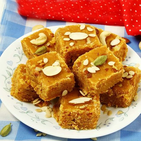 A traditional rich Gujarati sweet made from besan (gram flour) cooked in ghee, sugar and milk flavoured with cardamom and nuts and set. a exotic gram flour fudge or dessert from the traditional ancient gujarati and rajasthani cuisine. this besan and ghee based indian sweet dessert is popularly known as mohanthal, but it is known with other names like, mohanthar or mohan thal too. yet another traditional indian sweet recipe with the combination of besan flour, ghee and sugar. it has a significanc Mohanthal Recipe, Rajasthani Cuisine, Coconut Barfi Recipe, Barfi Recipe, Burfi Recipe, Sweet Recipe, Gram Flour, Indian Sweet, Indian Desserts