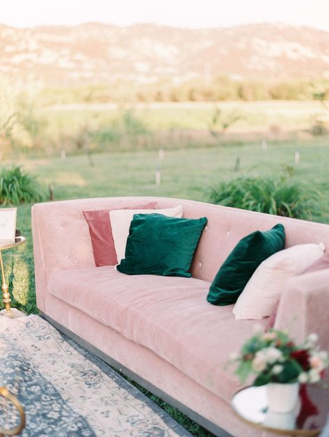 Wedding lounge with blush sofa and mauve, ivory, and emerald green pillows. Grey side chairs and a large rug with gold and glass table. Full Belly Farm reception by film photographer Cavin Elizabeth Photography Emerald Mauve Wedding, Emerald Green Blush Pink, Blush Emerald And Gold Wedding, Emerald And Mauve Wedding, Emerald Green Blush Pink Color Palettes, Emerald Pink Gold Wedding, Emerald Taupe Peach Wedding, Emerald Green And Blush Wedding, Emerald Green Pillows