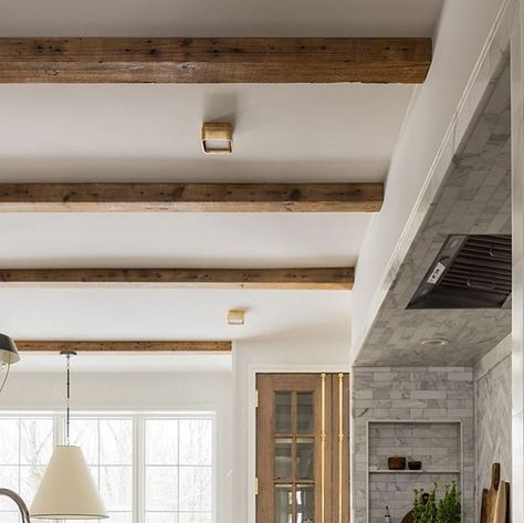 Jean Stoffer on Instagram: "Our #jsdhoneycreek kitchen just has all the cozy feels. Warm neutrals, a range alcove, a beautiful mixture of lighting, antique beams…. Do you have a favorite part?  @stofferhomecabinetry in Bromley Taupe. All lighting, hardware and most decor from @stofferhome Photographed by @stofferphotographyinteriors" Wooden Beams In Kitchen, Bromley Taupe, Beams In Kitchen, Kitchen With Beams, Range Alcove, Stove Alcove, Beam In Kitchen, Faux Ceiling Beams, Color Cabinets