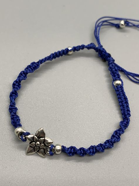 A dainty floral focal charm sets this minimalist woven bracelet apart from the rest.     A one of a kind artisan created dainty navy blue braid of polyester threads and silver tone beads. A simple but striking statement. Navy Blue Jewelry, Dr Marvel, Blue Weave, Woven Bracelet, Bracelet Blue, Woven Bracelets, Minimalist Bracelet, Blue Jewelry, Charm Set