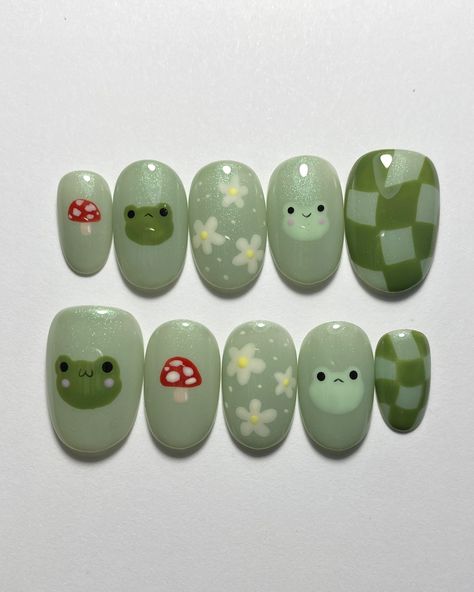 Cute little frog friends 💚 Custom Press-On Order: Tier 2 Nail Art on Extra Short Oval Nails *All press-on sets come with an application kit and instructions on how to apply and remove them Nail Art Products Used: Base color - @leafgelusa color 405 (green with glitter) Face details - @leafgelusa 001 (black) Nail art details - @mpa_onlinestore palette Top coat - @kokoistusa ultra glossy non wipe top gel Want a cute set like this one? Order a sizing kit from my shop- there are various options... Nail Ideas Disney Simple, Bigfoot Nails, Cute Mushroom Nail Designs, Extra Short Oval Nails, Nail Ideas Mushroom, Green Short Nails Ideas, Capybara Nails, Pokemon Nails Designs, Cute Nails Green