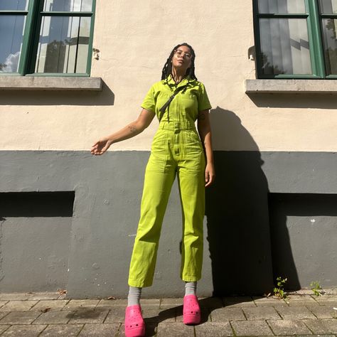 A girl with crochet faux locs posing in front of an old building. She is wearing pink siren clogs from crocs and a custom dyed junpsuit from big bud press in size S. Crocs Heels Outfit, Siren Crocs Outfit, Crocs Siren Clogs Outfit, Siren Clog Crocs Outfit, Big Bud Press Jumpsuit, Green Jumpsuit Outfit, Clog Outfit, Clogs Outfits, Crochet Locs