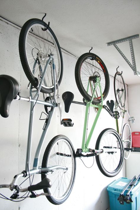 Three bikes hanging from hooks in a garage Bike Storage Inside, Bike Storage Wall, Bike Storage Home, Garage Bike Storage, Hanging Bike Rack, Bicycle Wall Mount, Bike Storage Garage, Bike Storage Solutions, Door Makeover Diy