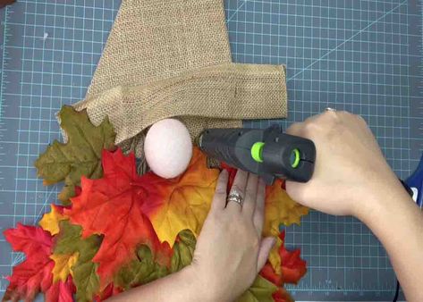 Gluing the burlap piece for added decoration on the gnome wreath Fall Gnome Wreath Tutorial, Parts Of The Nose, Gnome Wreath, Wreath Door, Old Christmas, Wreath Tutorial, Frame Wreath, Hot Glue Gun, Wreath Decor