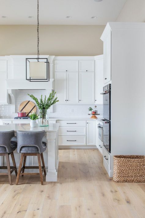 White Kitchen   White Oak Flooring   Fabric Bar Stools   Modern Kitchen   Tan Wall Paint   Box Pendant | Design by Scout Island Styling, Ruscus Greenery, Best White Paint Colors, Light Oak Floors, Round Marble Table, Tan Walls, Italian Ruscus, Vintage Style Rugs, Light Hardwood