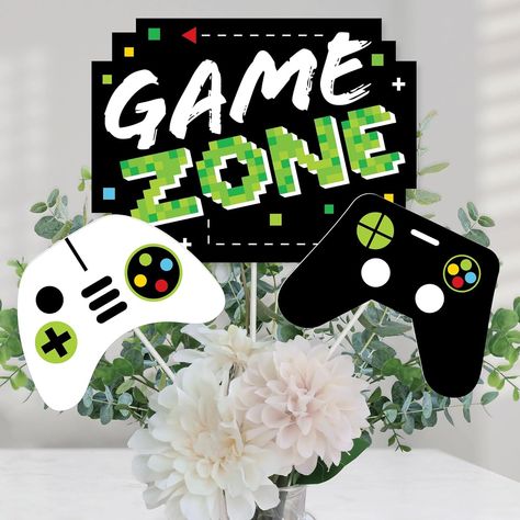 Game Zone Centerpiece Sticks include 15 video game table toppers in 3 different shapes, 15 wooden dowel sticks, and stickers for easy assembly. Game party table decorations are perfect for pixel video game parties and birthday parties. Game Zone Party Centerpiece Sticks Size 5 Game Zone Table Toppers, 10.5W x 8H 5 White Game Controller Table Toppers, 6.75W x 4.75H 5 Black Controller Table Toppers, 7W x 5H Unique designs and a variety of pieces make this table decor kit an impressive addition to any arcade themed party. EASY PARTY DECORATION: Game Zone table decorations can be used as centerpieces when attached to the included dowels and inserted into a vase or floral arrangement. Add them to apothecary jars to accent your pixel video game party or birthday party candy buffet. Table toppers Video Game Table, Pixel Video Game, Sugar Skull Party, Pixel Video, Video Games Birthday Party, Game Zone, Easy Party Decorations, Video Game Party, Video Games Birthday