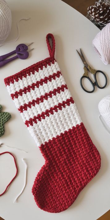 Crocheted Christmas stocking made with a free pattern – perfect for festive holiday decor – click to get the pattern. Crochet Stocking Garland Pattern Free, Crochet Grinch Stocking Pattern Free, Free Crocheted Christmas Stocking Pattern, Easy Crochet Christmas Stocking Pattern, Stockings Crochet Pattern Free, Free Crochet Christmas Stockings Patterns, Granny Square Stocking Crochet, Crocheted Mini Christmas Stockings Free, Small Crochet Stocking Pattern Free