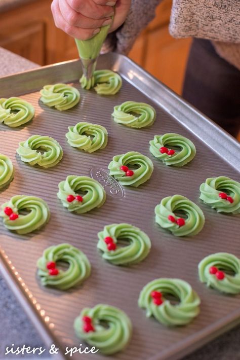 Wreath Spritz Cookies - Sisters and Spice...and everything nice Buttery Spritz Cookies Christmas, Christmas Spritz Cookies Decorating, Piped Spritz Cookies, Holiday Spritz Cookies, Swedish Spritz Cookie Recipe, Cute Holiday Cookies, Christmas Press Cookies, Wreath Spritz Cookies, Spritz Christmas Cookies