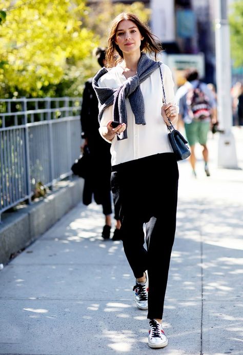 Gray knit sweater knotted around shoulders, white button-down blouse, black cropped trousers, and metallic sneakers Loose White Blouse, Model Street Style, Favorite Sweater, Carrie Bradshaw, Inspired Outfits, Fashion Week Street Style, Coco Chanel, Fashion Week Spring, Simple Outfits