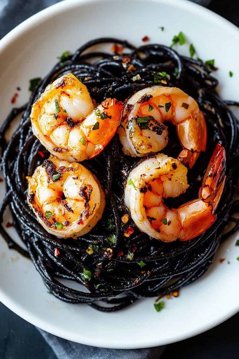 Looking for a Halloween dinner idea? This Vampire Pasta made with squid ink pasta, garlic, and shrimp is the ultimate spooky meal! The dark, mysterious noodles and savory shrimp create a hauntingly good dish that will thrill your guests. Add this festive recipe to your Halloween menu and serve up something eerie yet delicious! Black Pasta With Shrimp, Vampire Pasta, Vampire Recipes, Spooky Pasta, Beet Risotto, Black Pasta, Pasta Garlic, Ink Pasta, Pasta With Garlic