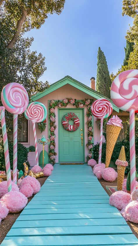 Whimsical front yard with candy-themed decorations, giant lollipops, and ice cream cones, leading to a green door. Christmas Outdoor Candyland, Christmas Candy House Decorations, Candy Cane Wonderland Decorations, Candy Land Door Ideas, Pink Outdoor Christmas Lights, Pink Christmas Porch Decor, Pastel Outdoor Christmas Decor, Gingerbread House Diy Outdoor, Candyland Christmas Outdoor Decorations