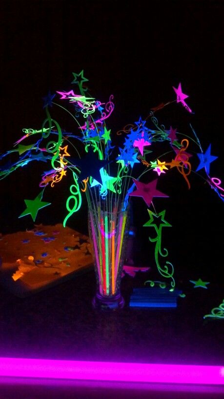 Young womens "Let your talents glow" theamed night in Excellence Centerpiece. All lit up by black light. Stars are made from neon poster board. Glow stick are in base, not cracked to glow. Black light lights them up. Light Up Centerpieces Diy, Glow In The Dark Table Centerpiece, Glow Stick Decorations, Glow Stick Centerpieces Diy, Glow Table Decorations, Glow Party Table Centerpieces, Neon Theme Centerpieces, Glow In Dark Centerpieces, Glow In The Dark Party Centerpieces