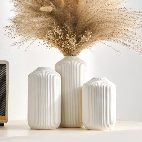 PRICES MAY VARY. UNIQUE WHITE CERAMIC VASE SET: You will be mesmerized by our exquisite white ceramic vase set. The Modern Boho Vase Set includes 3 vases of different shapes and sizes, the texture of the vertical stripes on top of each vase enriches the visual hierarchy and enhances the unique artistic feel ！The modern farmhouse vase set is perfect table centerpieces. They also look great on shelf, coffee table, entryway table, and more. Create your ideal home decor aesthetic with this set of bo Boho Bedroom Shelf Decor, Pampas Baby Shower Centerpiece, Organic Modern Shelf Decor, Modern Living Room Accessories, White Vase Centerpiece, Master Suite Decor, Modern Shelf Decor, Boho Vases, Vase For Pampas