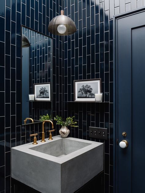 Walls are covered in Fireclay tile in Navy Blue. The vanity has a custom concrete basin by Newbold Stone Architectural Concrete and steel base from Metal Works Austin. The custom steel shelf and steel-edged mirror are paired with a perforated pendant by Allied Maker. Blue Tile Powder Room, Blue Tiled Bathroom, Dark Blue Tile, Navy Blue Tile, Glamorous Bathroom, Blue Tile Wall, Cabin Renovation, Staircase Outdoor, Blue Bathroom Decor