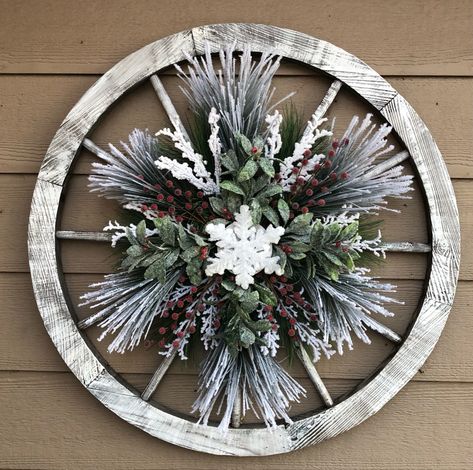 I made this snowflake wreath and hung it on a whitewashed wagon wheel Wood Wagon Wheel Decor, Wooden Wagon Wheels Ideas, Wagon Wheel Decor Outdoor Christmas, Christmas Wheel Wreath, Christmas Bike Wheel Wreath, Wagon Wheel Crafts, Wagon Wheel Christmas Decor Outdoor, Wagon Wheel Wreath Diy, Wagon Wheel Christmas Wreath