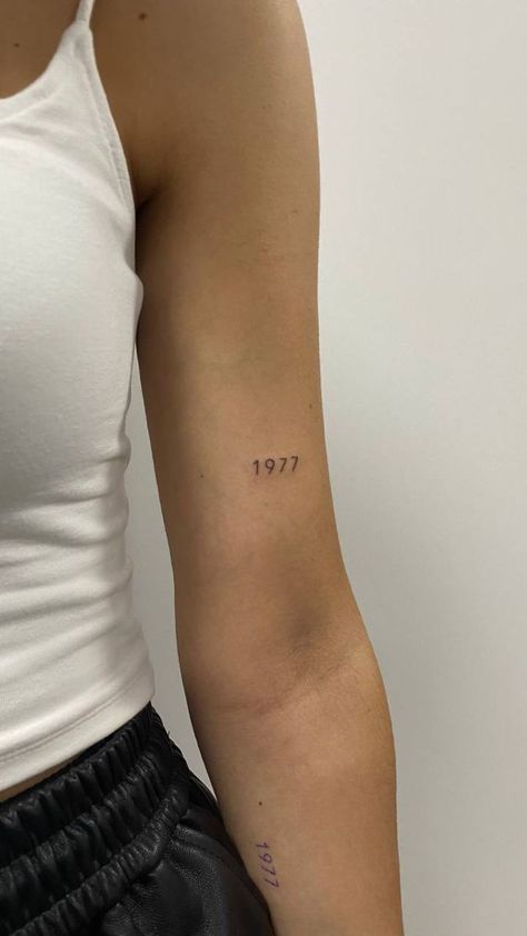 Date Placement Tattoos, Minimalist Tattoo On Arm For Women, Above Arm Tattoo, Date On Back Of Arm Tattoo, Year Tattoos On Arm, Dainty Tattoos Year, Year Tattoo Number Dainty, Mini Date Tattoo, Medium Tattoo Ideas Men