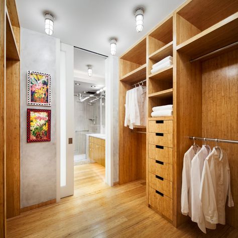 This spacious walk-in dressing room and closet provides ample storage while still feeling chic and inviting. Industrial overhead lights add a unique touch and cultivate a modern aesthetic. Walk Through Closet To Bathroom, Bathroom With Dressing Room, Closet To Bathroom, Walk Through Closet, Contemporary Closet, Ideas Closet, Dressing Design, Creative Closets, Walking Closet