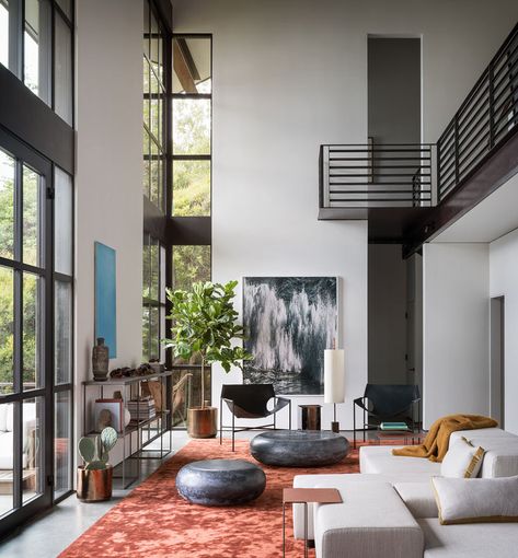 Living Room Ideas - Double height windows in this modern living room frame the picturesque bay and illuminate the silk Tai Ping rust carpet, while the Laurier Blanc acrylic glass Hekla Side Table & Stool, complement the Taylor Forest club chair, that sits beneath the Amir Zaki waterfall photograph. #LivingRoomIdeas #InteriorDesign #LivingRoom #ModernInterior High Ceiling Living Room, Interior Design Minimalist, Unusual Furniture, Loft Spaces, Design Living Room, A Living Room, High Ceiling, 인테리어 디자인, Modern House Design